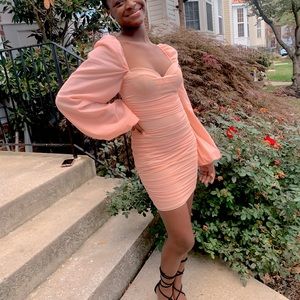 I’m selling this blush ohpolly body con dress with long puffy sleeves.